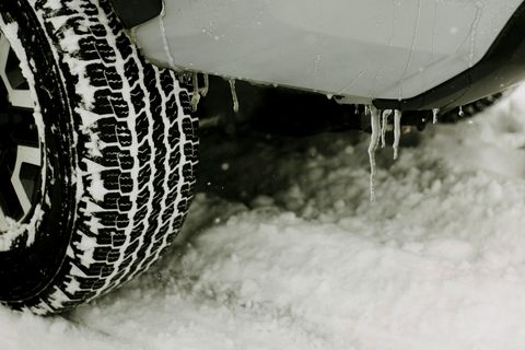 Pneu d'hiver à crampons profonds sur une auto stationnée dans la neige